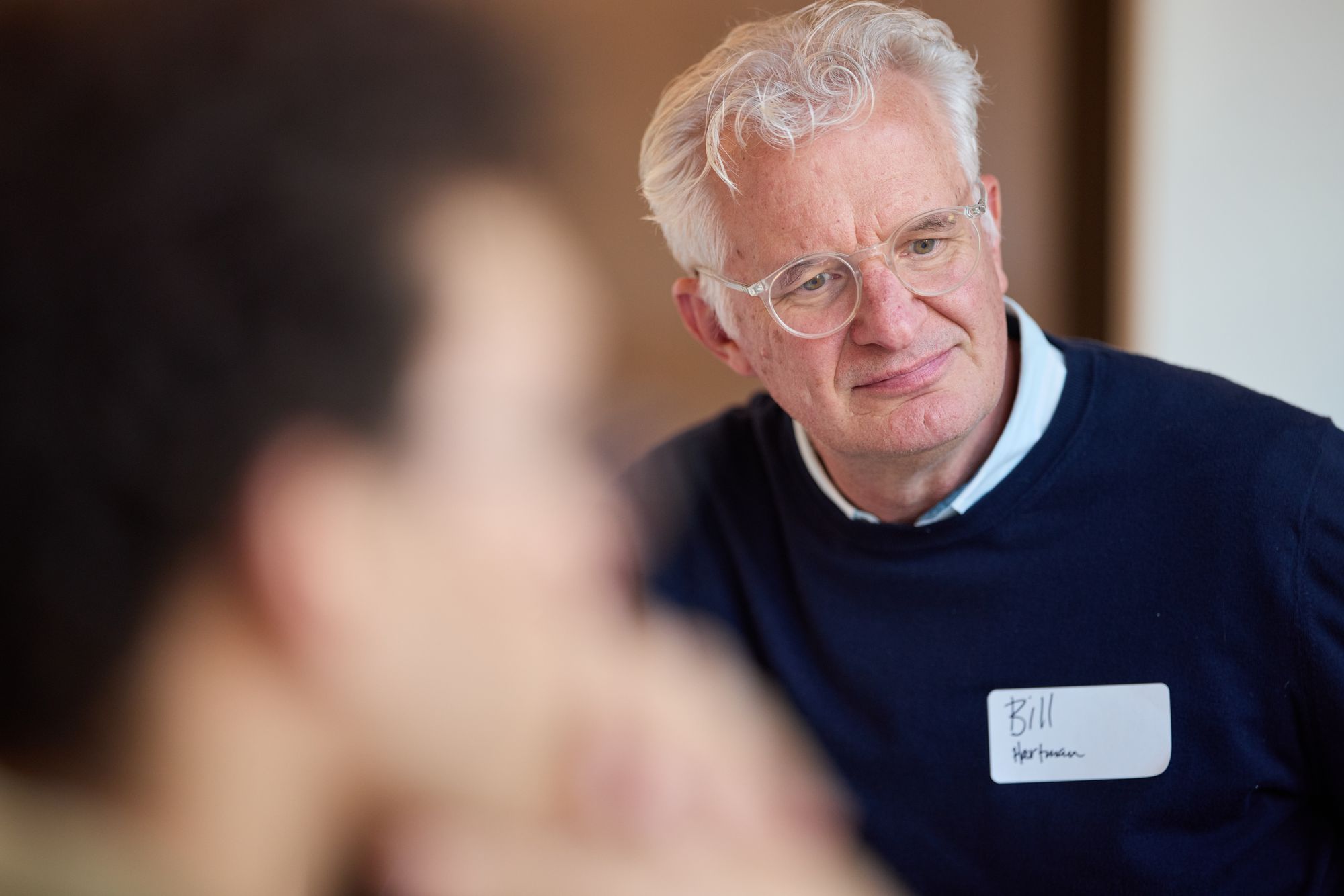 A thoughtful participant looks on.